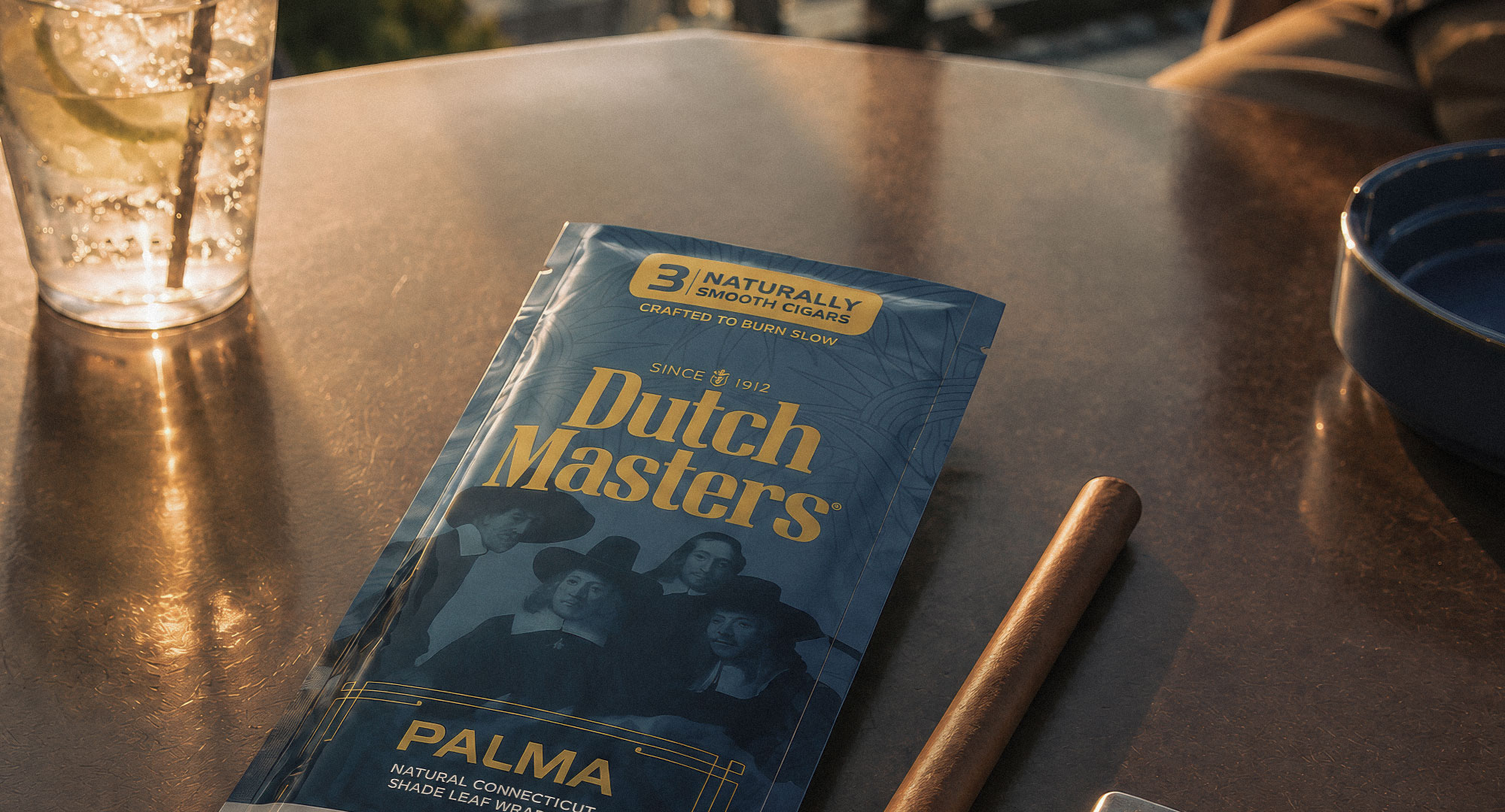 Dutch Masters cigar packaging hero image on a table with warm evening light